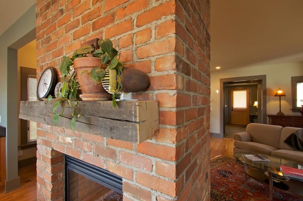 brick fireplace with wooden mantle.