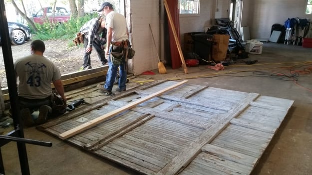 this photo shows the process of repurposing the a historic barn door