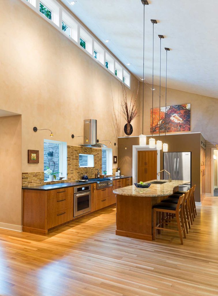 Open layout kitchen with high ceilings and no upper cabinets for accessibility and aging in place